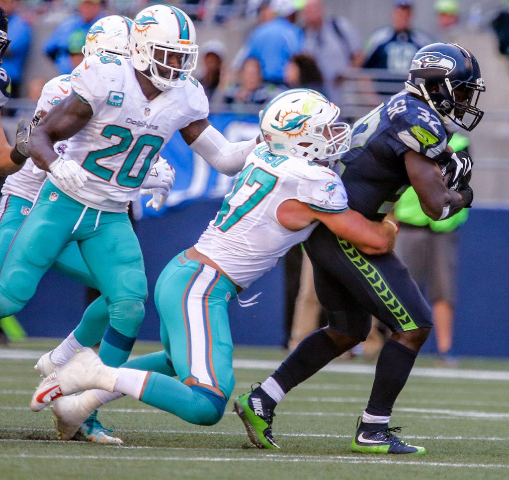 Dolphins linebacker Kiko Alonso tackles Seahawks running back Christine Michael with Dolphins safety Reshad Jones, far left, closing at Century Link Field in Seattle on September 11, 2016. The Seahawks defeated the Dolphins 12-10. (Kevin Clark / The Herald)
