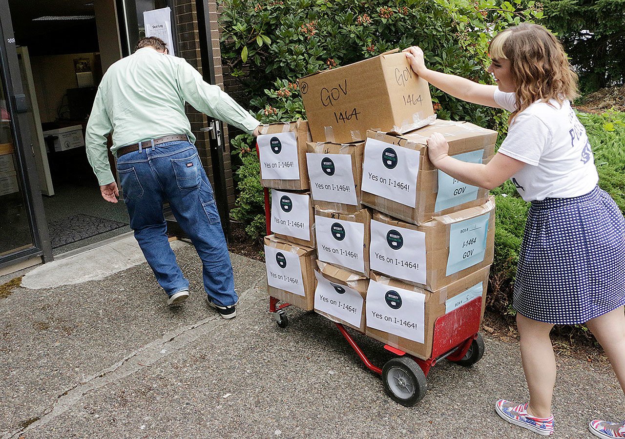 In this July 8 photo, supporters of a proposed campaign finance reform ballot measure arrive to turn in boxes of signed petitions in Olympia. Washington voters will soon decide whether or not to make the most sweeping changes to the state’s campaign finance system in decades. (AP Photo/Rachel La Corte, File)