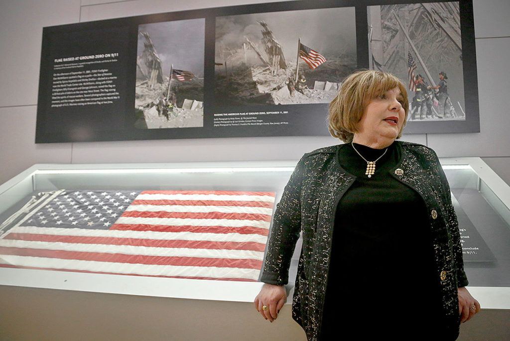 Shirley Dreifus, the original owner of the American flag, left, that firefighters hoisted at ground zero in the hours after the 9/11 terror attacks, speaks during an interview at the Sept. 11 museum Thursday in New York. After disappearing for more than a decade, the 3-foot-by-5-foot flag goes on display Thursday at the museum. (AP Photo/Bebeto Matthews)
