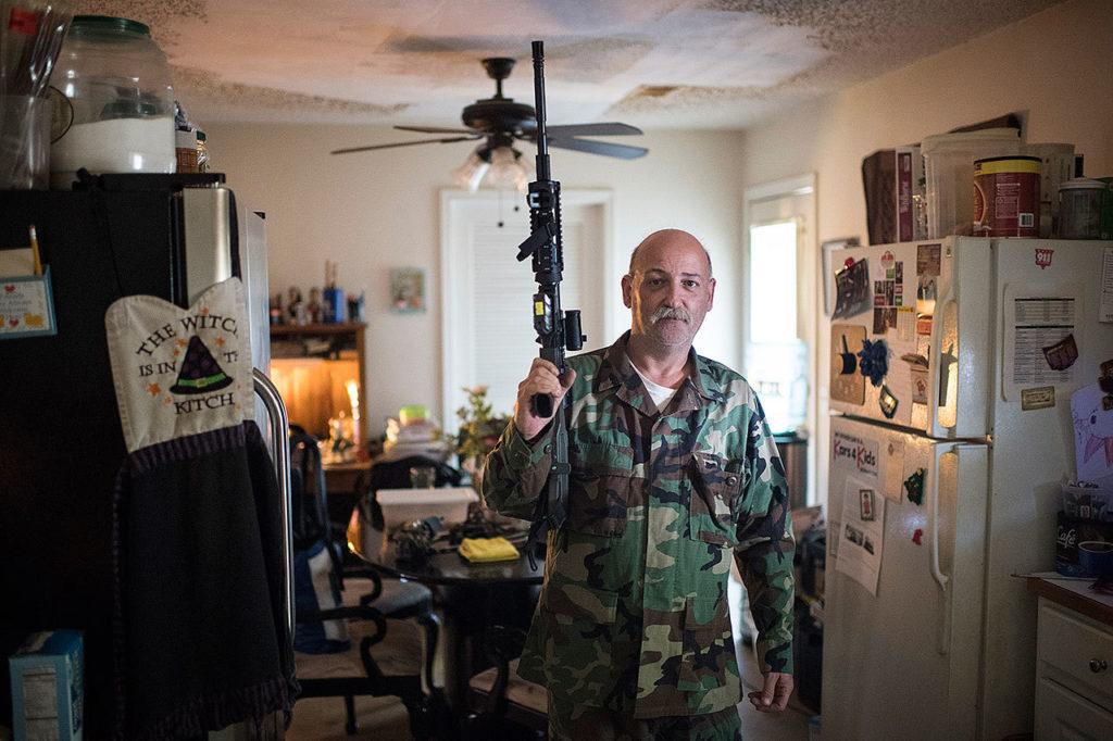 Jim Cooley stands for a portrait at his home with his AR-15 semiautomatic rifle. (Washington Post/Jabin Botsford)
