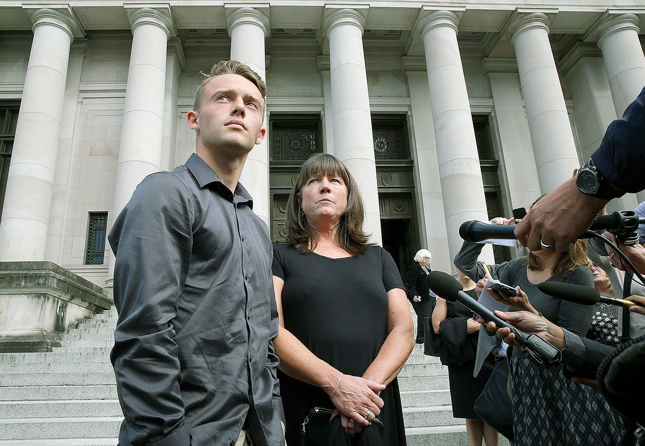 Stephanie McCleary and her son, Carter, 17, left, talk to reporters Wednesday in Olympia after a Washington State Supreme Court hearing on the ongoing battle surrounding the state’s constitutional requirement to properly fund basic education. Stephanie McCleary is one of the plaintiffs in the case. (AP Photo/Ted S. Warren)