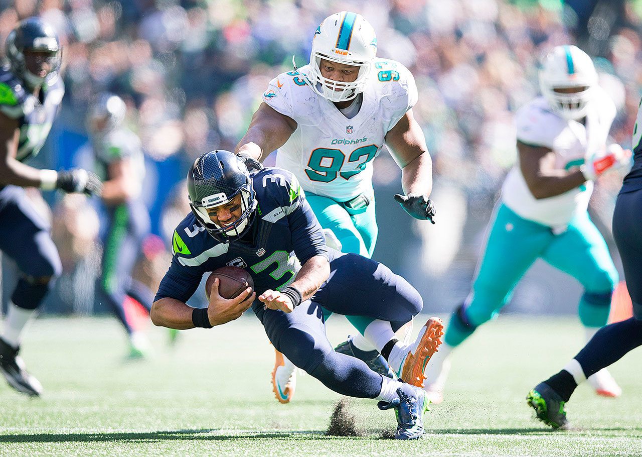 Miami Dolphins defensive tackle Ndamukong Suh (93) steps on Seattle Seahawks quarterback Russell Wilson’s foot in the third quarter of the game in Seattle on Sunday. (Dean Rutz/The Seattle Times via AP)