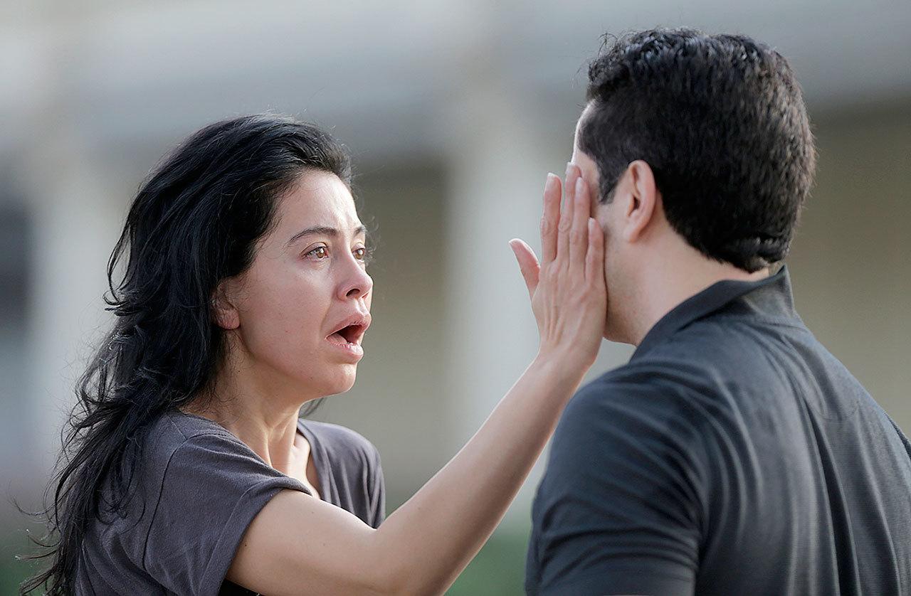Jennifer Molleda looks at the blood specked face of her husband, Alan Wakim, who had two bullets whiz by his face after going through his windshield during a shooting along Wesleyan at Law Street that left multiple people injured and the alleged shooter dead, Monday in Houston. (Mark Mulligan/Houston Chronicle via AP)