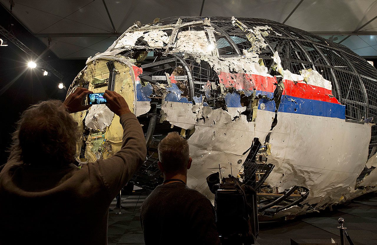 In this Oct. 13, 2015 photo, journalists take images of part of the reconstructed forward section of the fuselage after the presentation of the Dutch Safety Board’s final report into what caused Malaysia Airlines Flight 17 to break up high over Eastern Ukraine last year, killing all 298 people on board, during a press conference in Gilze-Rijen, central Netherlands. Relatives of victims of the shooting-down of a Malaysia Airlines jetliner over Ukraine more than two years ago were gathering Wednesday to learn the preliminary results of a Dutch-led criminal probe of the disaster. (AP Photo/Peter Dejong, File)