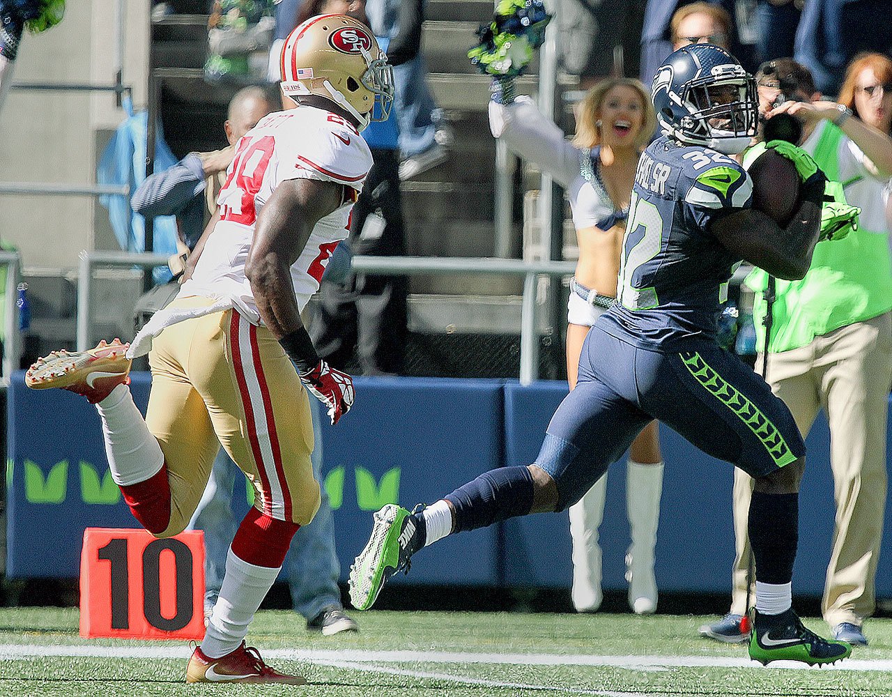 Seahawks running back Christine Michael (right) eyes 49ers safety Jaquiski Tartt on his way to the end zone for a 41-yard touchdown Sunday at CenturyLink Field in Seattle. (Kevin Clark / The Herald)