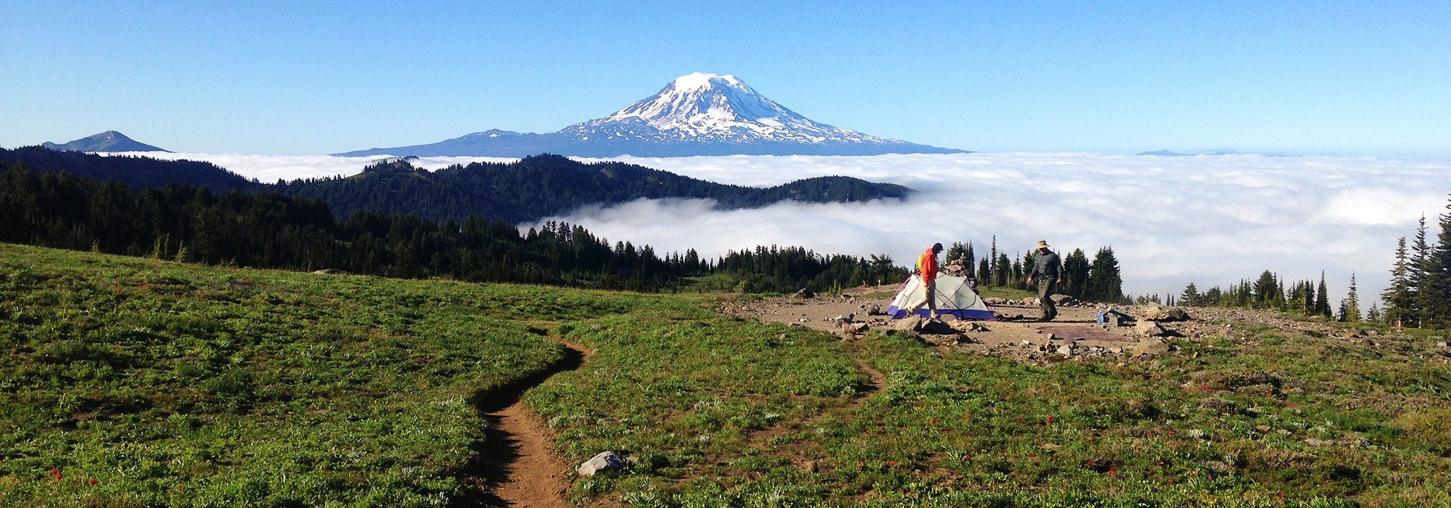 Backpackers pack up their camp in the Goat Rocks Wilderness, with Mount Adams rising up to the south. (Jessi Loerch/The Herald)