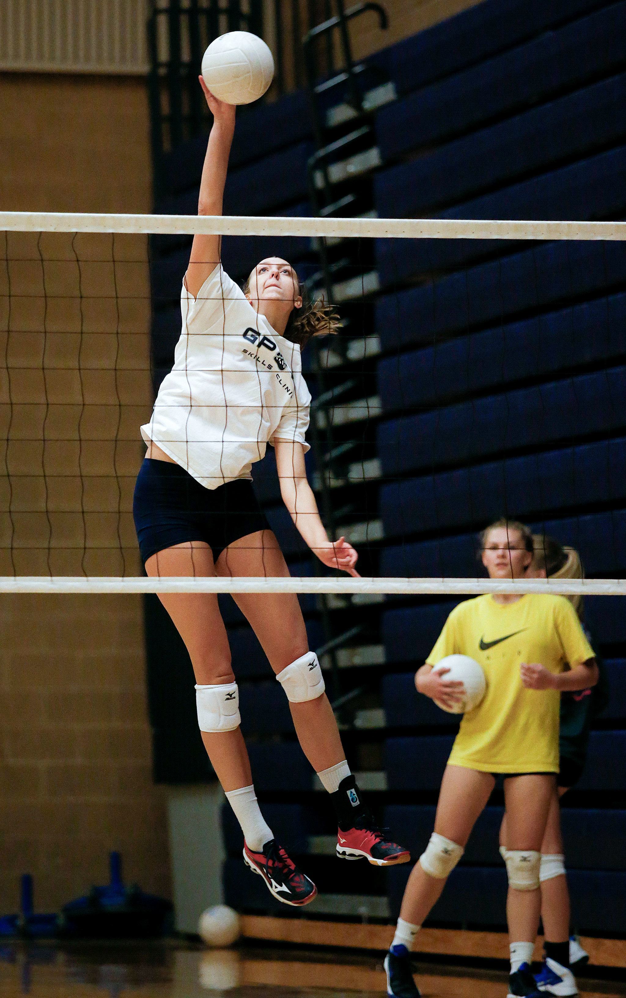 High above the net, 6’4” Glacier Peak middle blocker Lauren Sanders spikes the ball as she practices with her Grizzlies teammates on Monday, Sept. 5, 2016 in Snohomish, Wa. (Andy Bronson / The Herald)