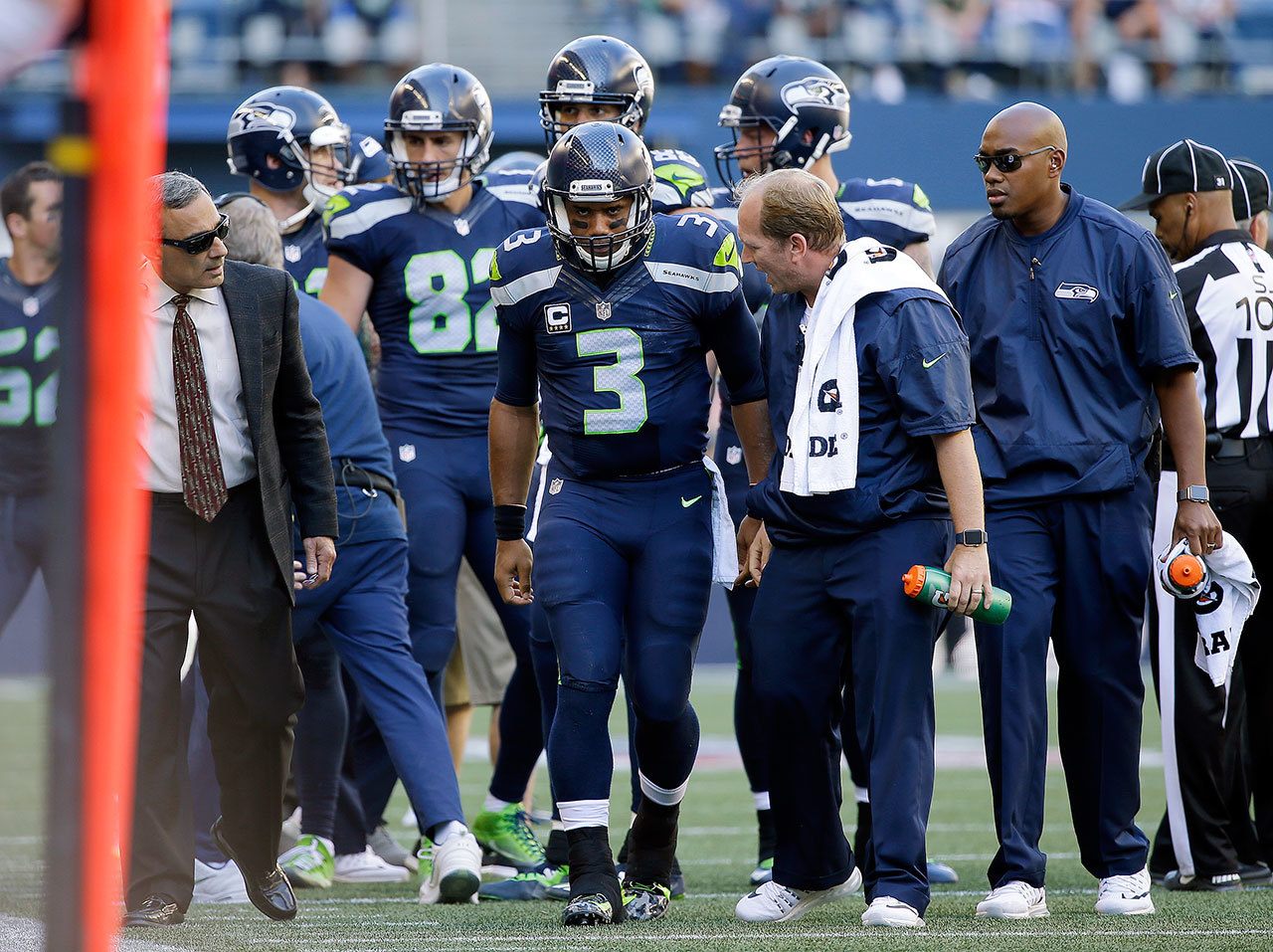 Seattle Seahawks quarterback Russell Wilson (3) is assisted off the field after injuring his knee in the second half of an NFL game Sunday in Seattle. (AP Photo/Ted S. Warren)