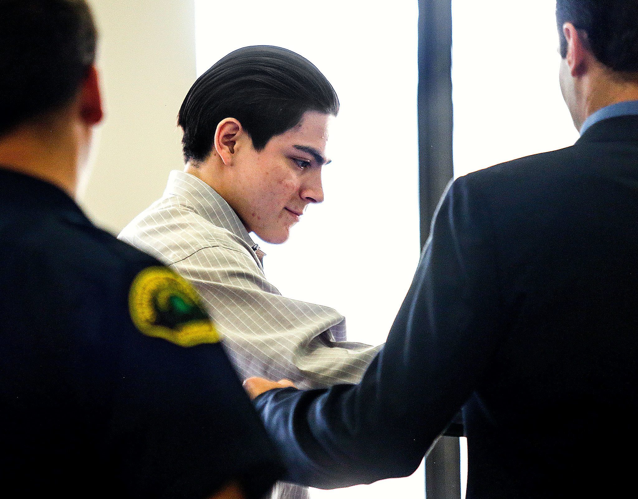 Chris Gonzalez-Garcia is handed over to his defense attorney, Paul Thompson, at the start of his trial Thursday. He is accused of strangling to death Chris Davis, whom he contacted through an ad on Craigslist last year. (Dan Bates / The Herald)