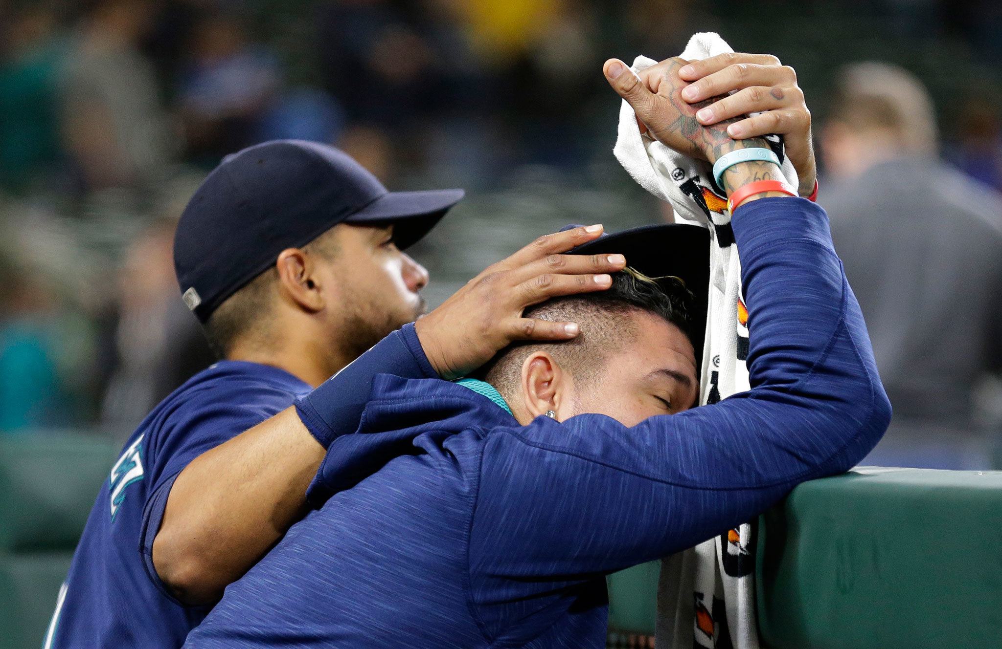 The Mariners’ Franklin Gutierrez (left) consoles pitcher Felix Hernandez (right) after the Athletics defeated the Mariners 9-8 in 10 innings Saturday in Seattle. (AP Photo/Ted S. Warren)