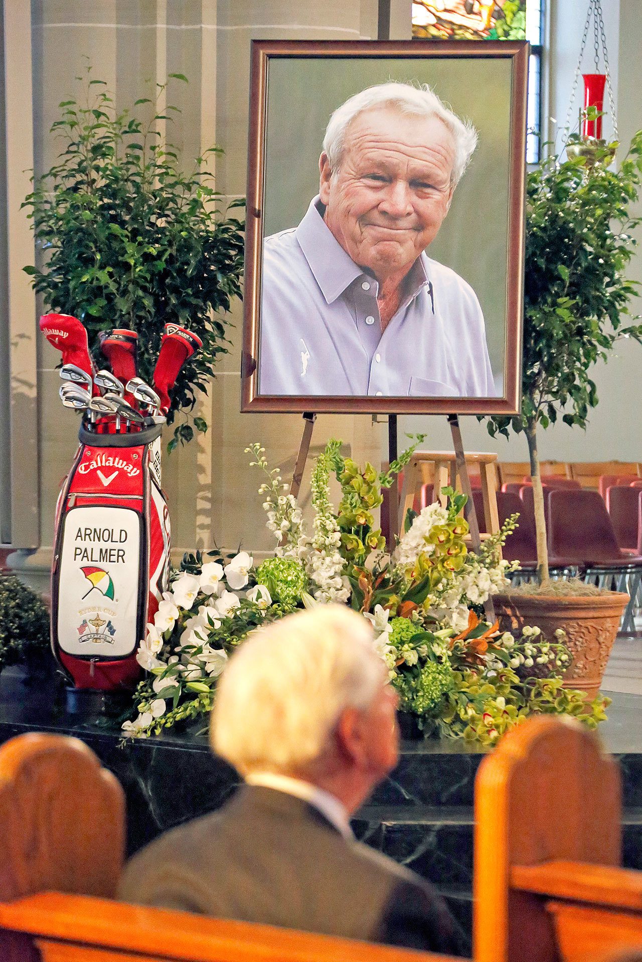 A set of golf clubs and a photo of Arnold Palmer sit in the Basilica at Saint Vincent College in Latrobe, Pa., during a memorial service for the iconic golfer in his hometown on Tuesday. (AP Photo/Gene J. Puskar)