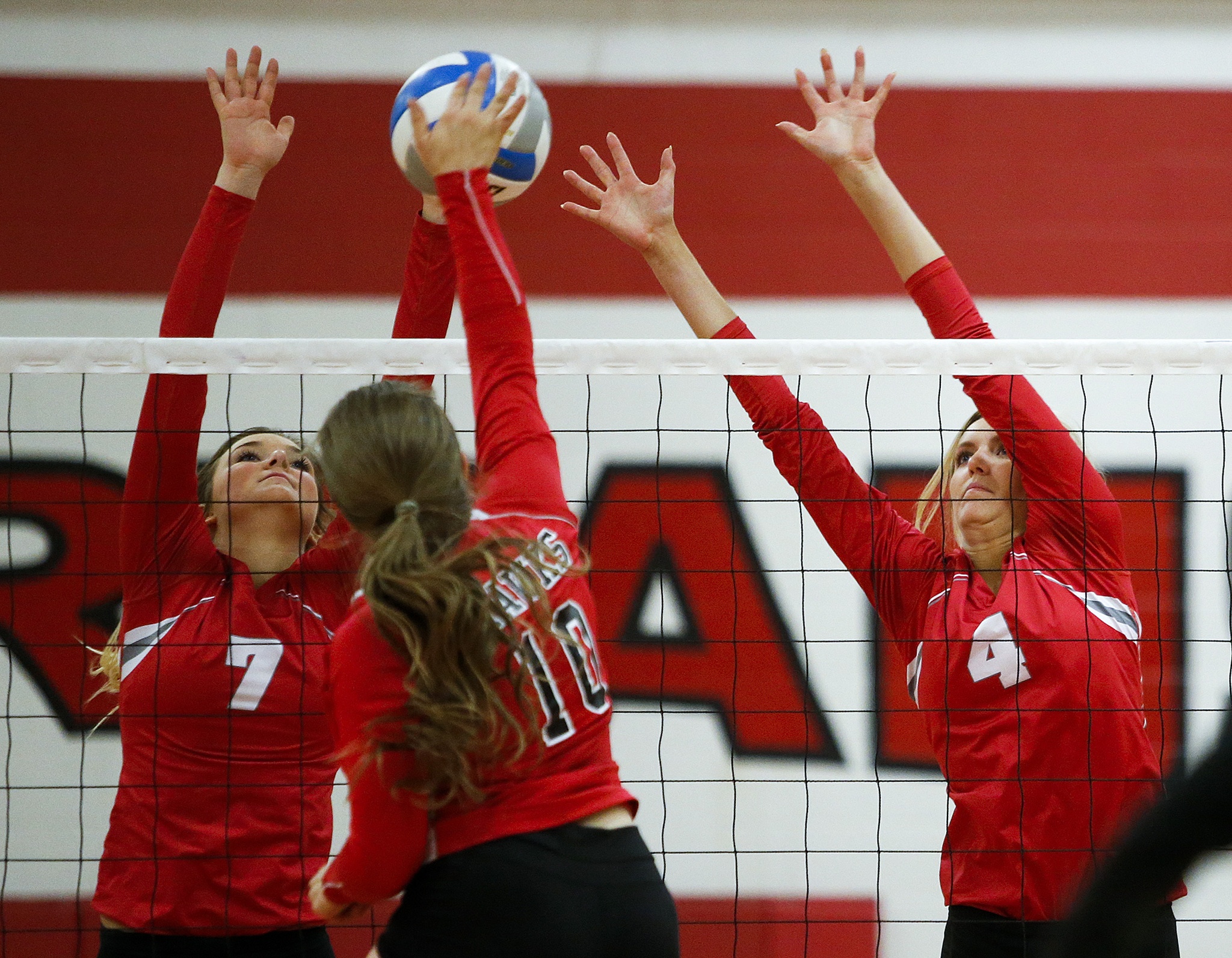 Stanwood’s Taya Shoemaker (7) and Devon Martinka (4) jump up to block a spike from Mountlake Terrace’s Leeann Weatherby (10) during a game at Stanwood High School on Tuesday, Oct. 11. (Ian Terry / The Herald)