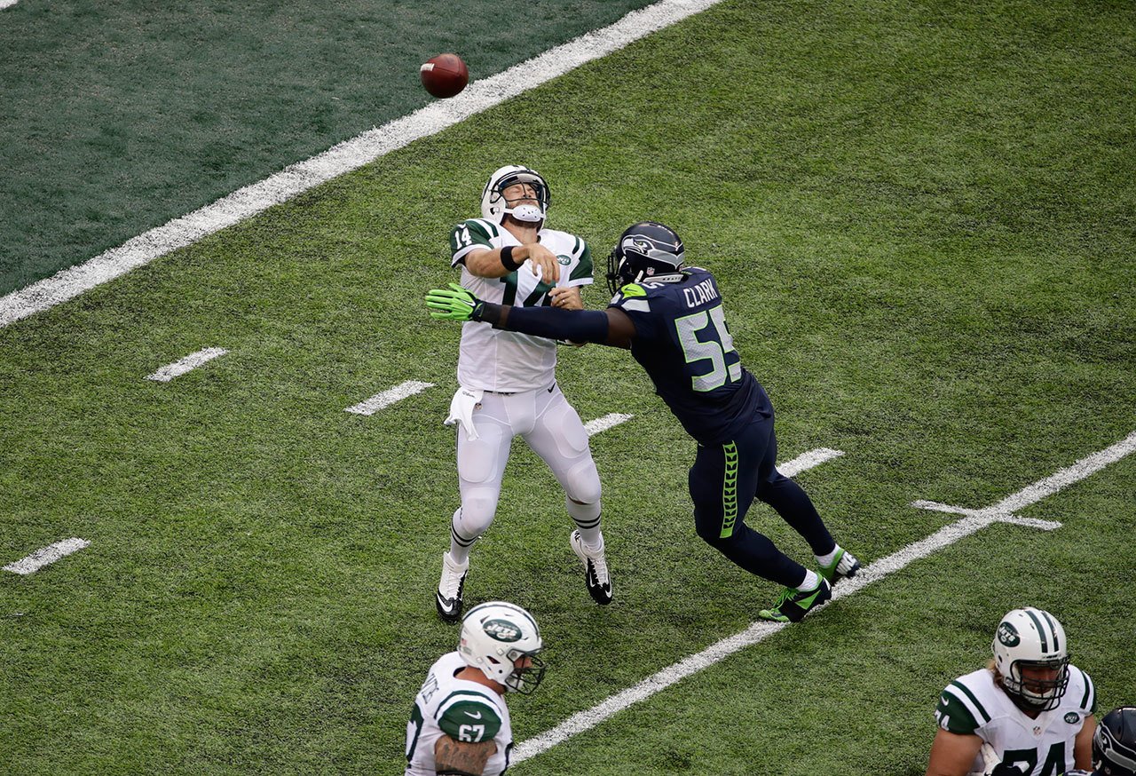 Seahawks defensive end Frank Clark (55) hits Jets quarterback Ryan Fitzpatrick (14) as he throws a pass during a game last Sunday in East Rutherford, N.J. (AP Photo/Peter Morgan)