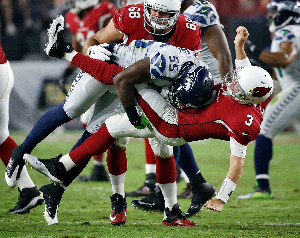 Cardinals quarterback Carson Palmer (3) is hit after the throw by Seahawks defensive end Frank Clark (55) during the first half of a game Oct. 23 in Glendale, Ariz. (AP Photo/Ross D. Franklin)
