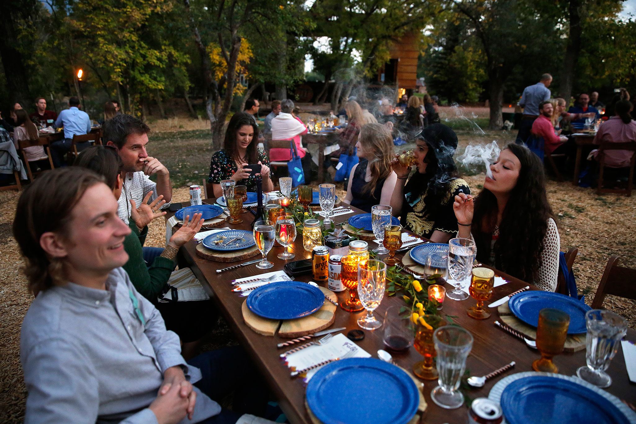 Diners smoke marijuana as they eat dishes prepared by chefs during an evening of pairings of fine food and craft marijuana strains served to invited guests dining this month at Planet Bluegrass, an outdoor venue in Lyons, Colorado. (AP Photo/Brennan Linsley)
