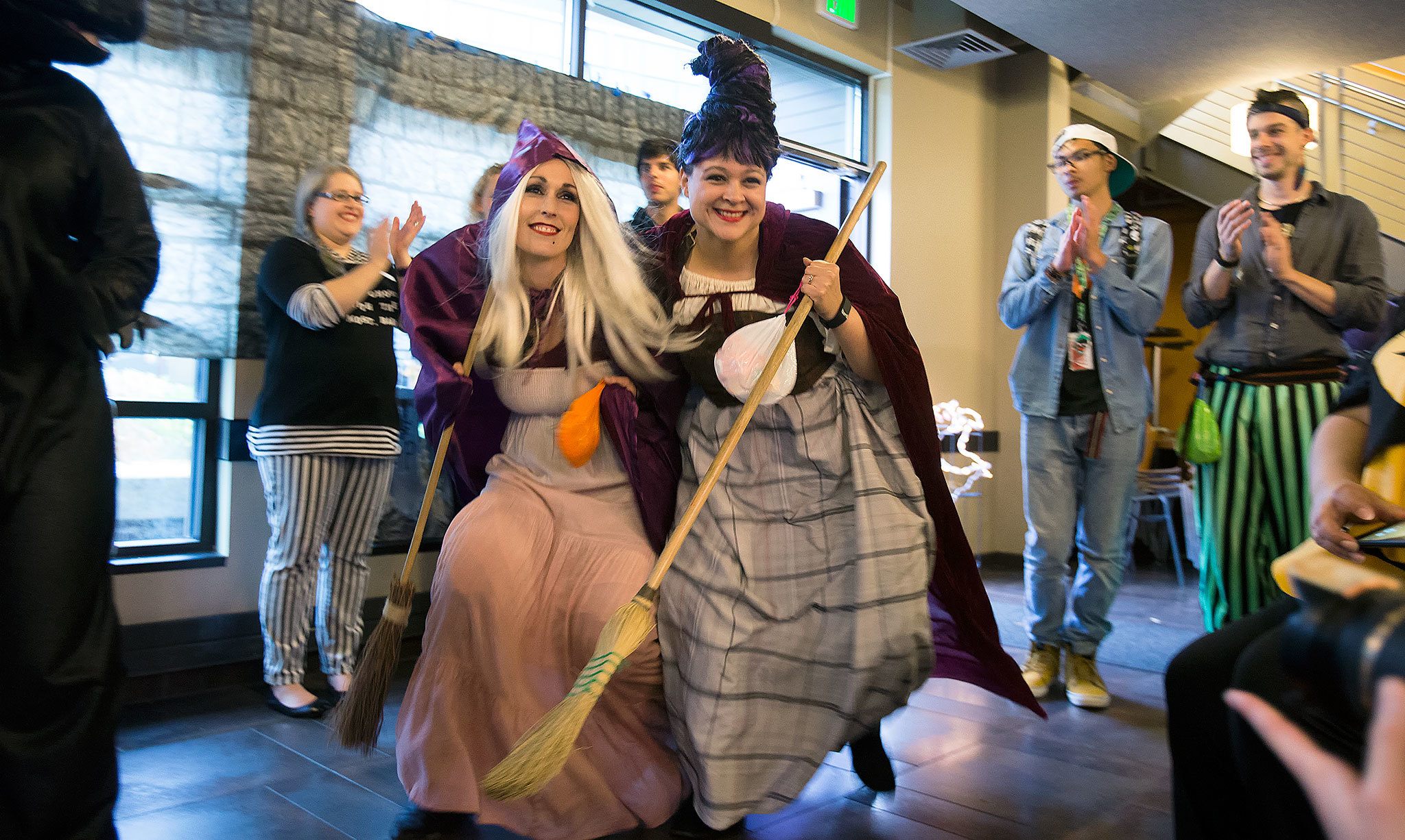 Everett Community College’s Elise Mayes (left) and Stacy Siler creep around as they accept their Faculty and Staff second-place win as the Sanderson Sisters, from the movie “Hocus Pocus,” during the Hallo-Scream Contest at Everett Community College on Monday, Oct. 31, in Everett. (Andy Bronson / The Herald)