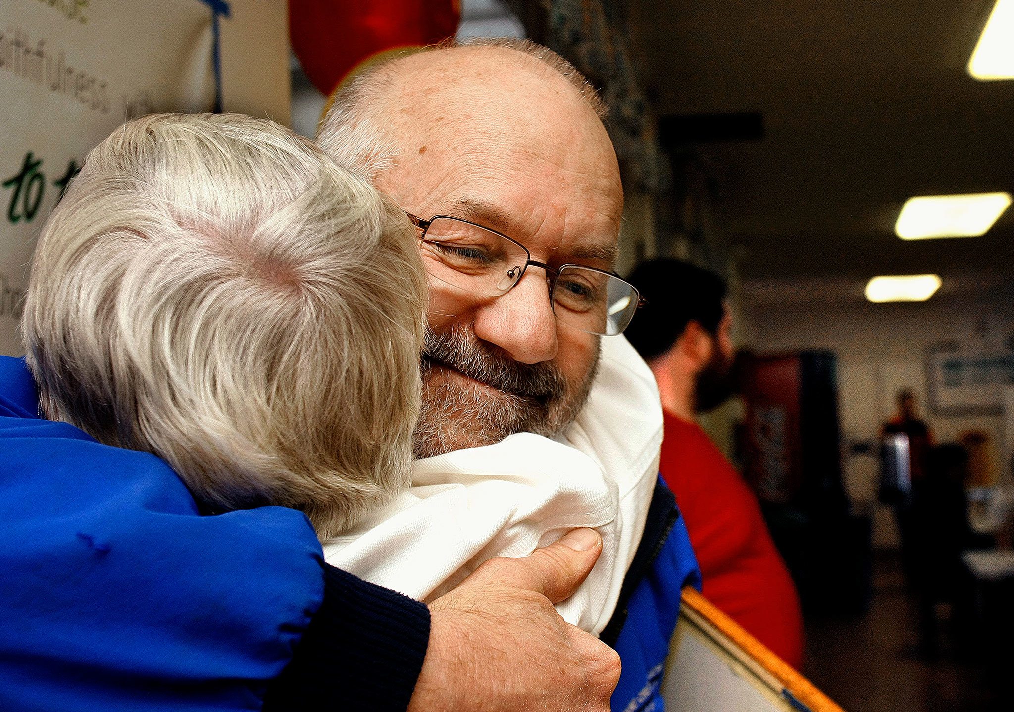 Frank Fargo, who offers free showers out of his trailer, is among 2016 KSER Voice of the Community Award winners. He is shown here in 2012 getting a hug from Lois Sugars at Everett’s First Presbyterian Church, where he provides showers during a weekly dinner for people who are homeless. (Sarah Weiser / The Herald)