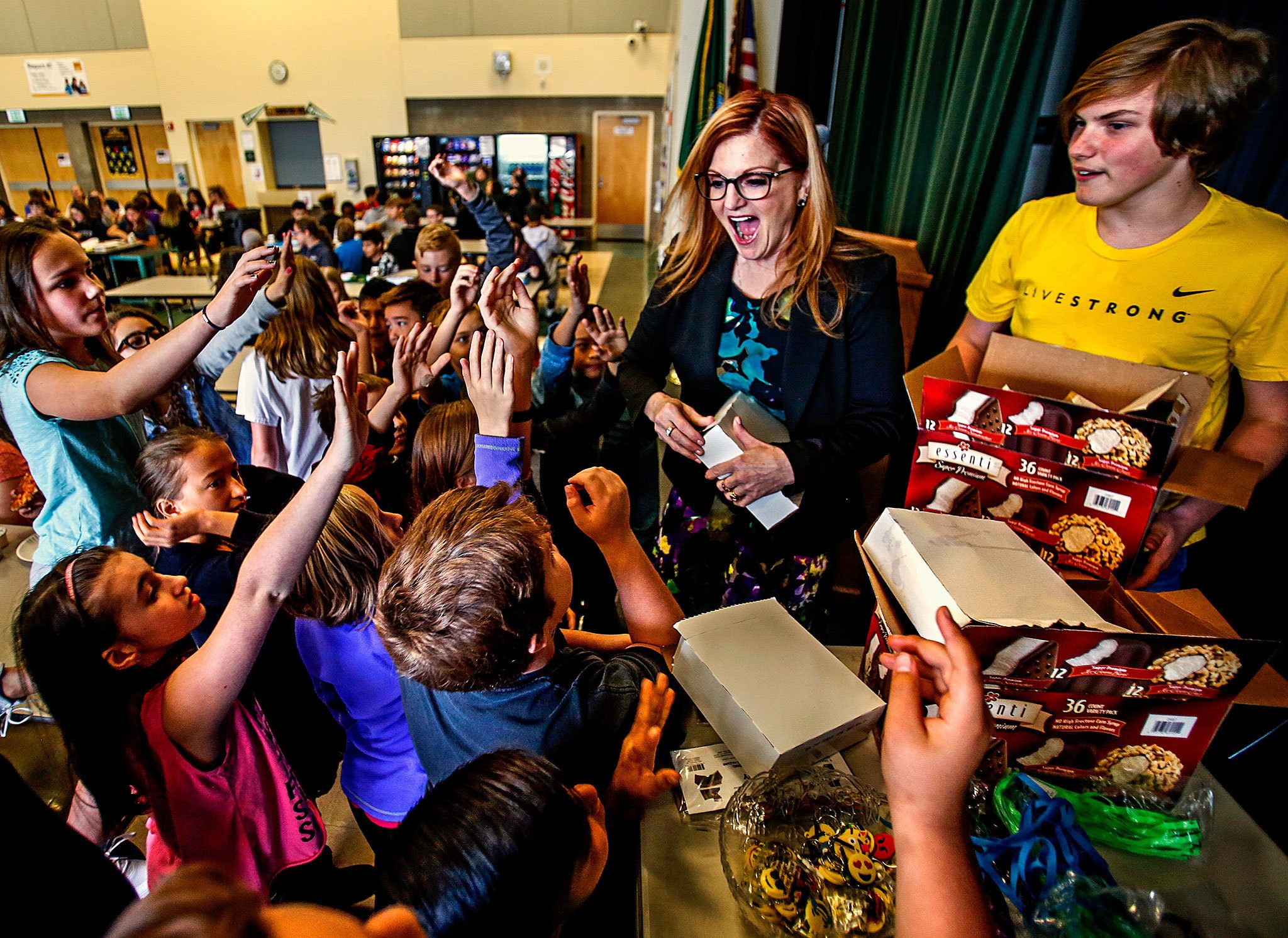 Assistant Principal Carmen Boggs passed out ice cream bars last week to Evergreen Middle School students who acquiredlibrary cards. On Monday, Boggs passed out ice cream bars to those kids and others who could name one thing you cando in a library besides check out books. “I was shocked by how many kids didn’t know what a library is,” Boggs said. “SoI started this thing, and it has kind of grown from there.” Assisting Boggs is Christopher Bakko, 13. (Dan Bates / The Herald)