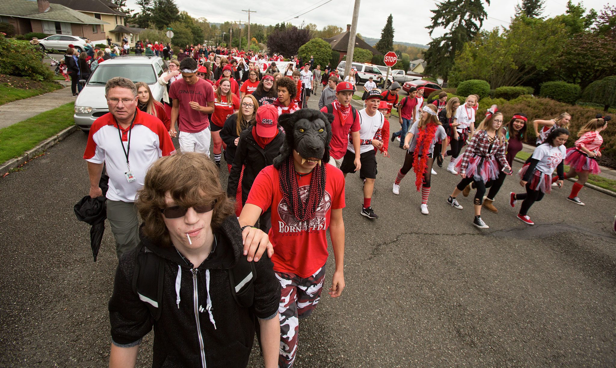 Hunter Gillgan leads Ethan De Soto (wearing mask) during Friday’s annual Serpentine Parade, a homecoming tradition for Snohomish High School students. (Andy Bronson / The Herald)