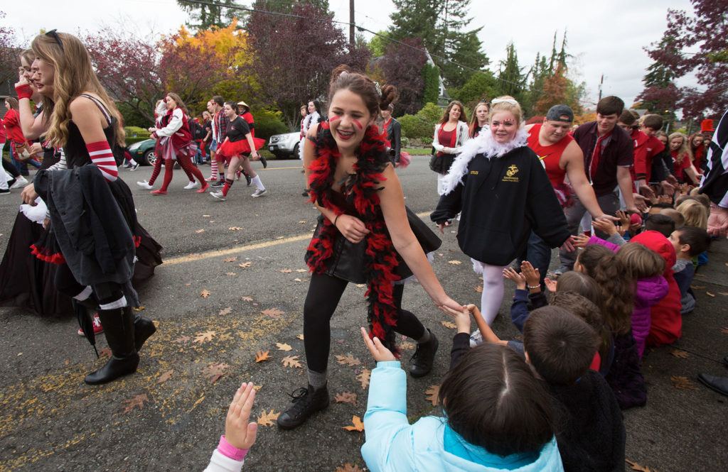 Snohomish High School students slap hands with Central Elementary students during the annual Serpentine Parade on Friday. (Andy Bronson / The Herald)
