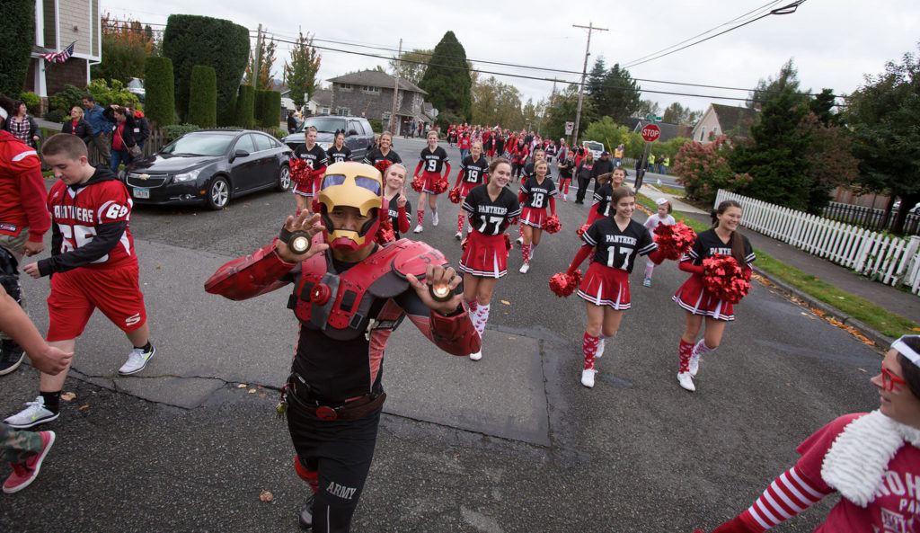 English teacher Tim Fraser-Bumatay wears an Iron Man costume as he and Snohomish High School students walk in the annual Serpentine Parade on Friday, a tradition for generations of students. (Andy Bronson / The Herald)
