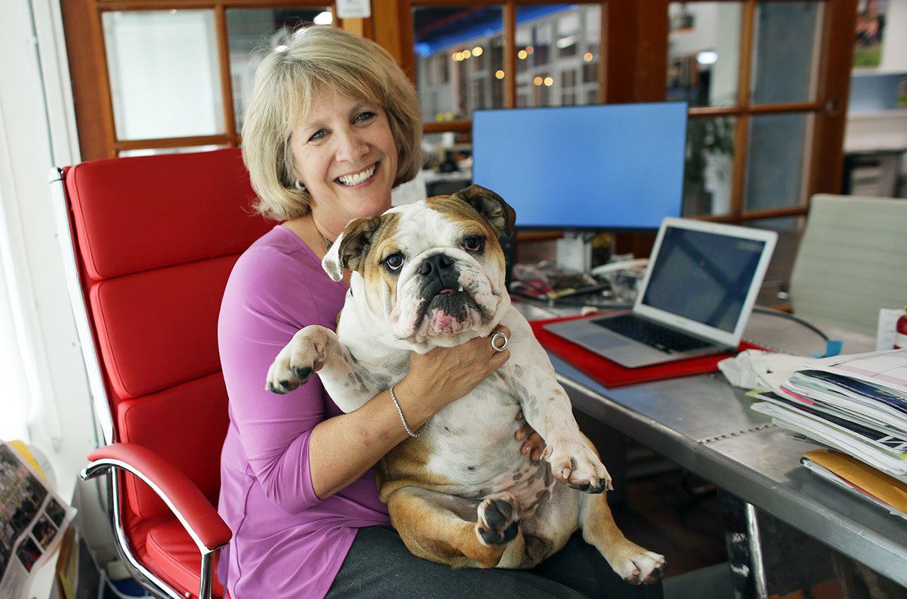 In this Oct. 18 photo, Barbara Goldberg, CEO of O’Connell & Goldberg Public Relations, poses for a photograph with her bulldog Rosie, at her office in Hollywood, Florida. Goldberg is a small business owner who believes pets improve the quality of their work life, boosting morale and easing tension for staffers. (AP Photo/Lynne Sladky)