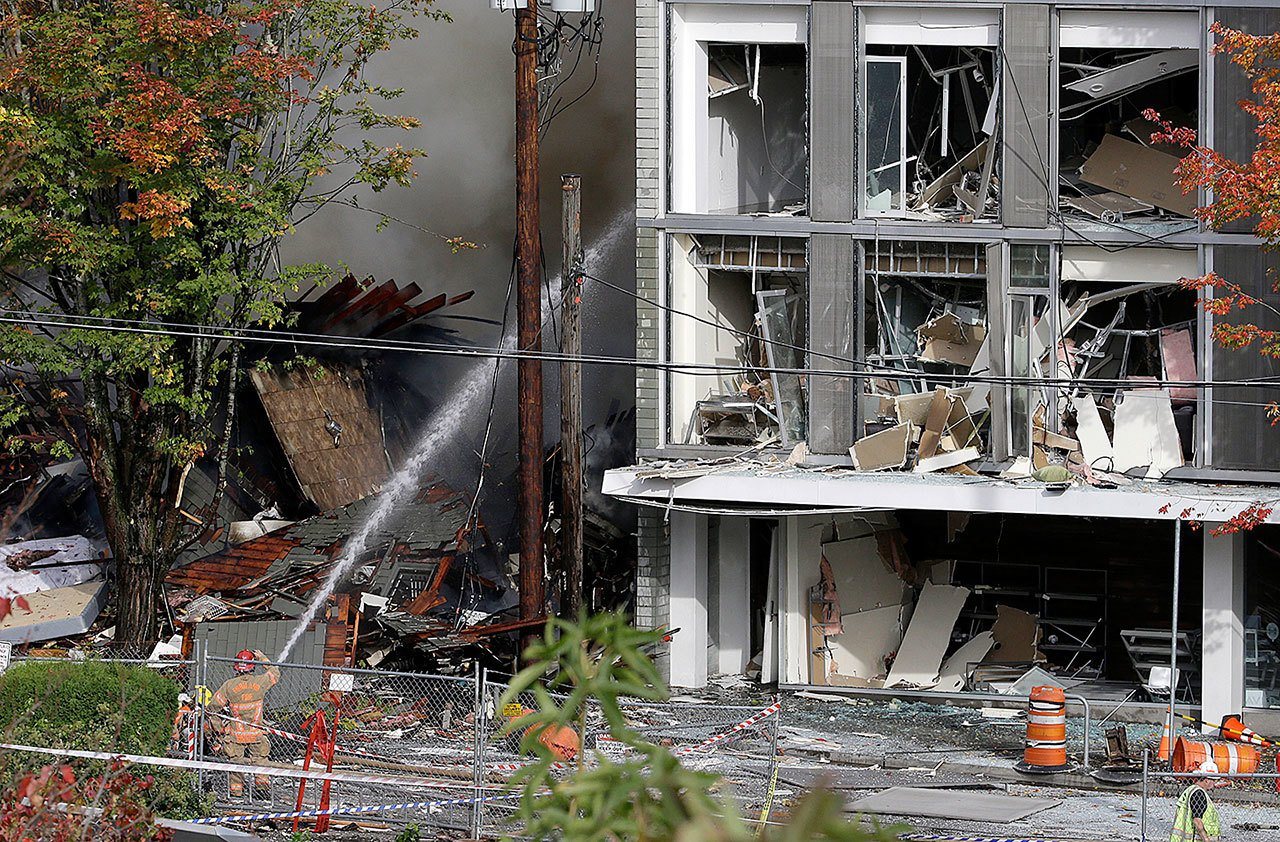 A firefighter battles a blaze after a gas explosion in Portland, Oregon, on Wednesday, Oct. 19. A powerful natural gas explosion that neighbors said felt like an earthquake rocked the busy shopping district, injuring three firefighters, two police officers and three civilians. One building was reduced to rubble and the exterior of one side of another building had been ripped off, its windows blown out. (AP Photo/Don Ryan)