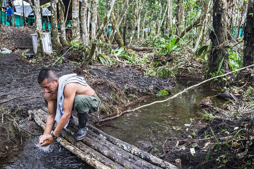 A FARC guerilla fighter from the southern bloc washes himself in the base camp. (The Washington Post/Joao Pina)
