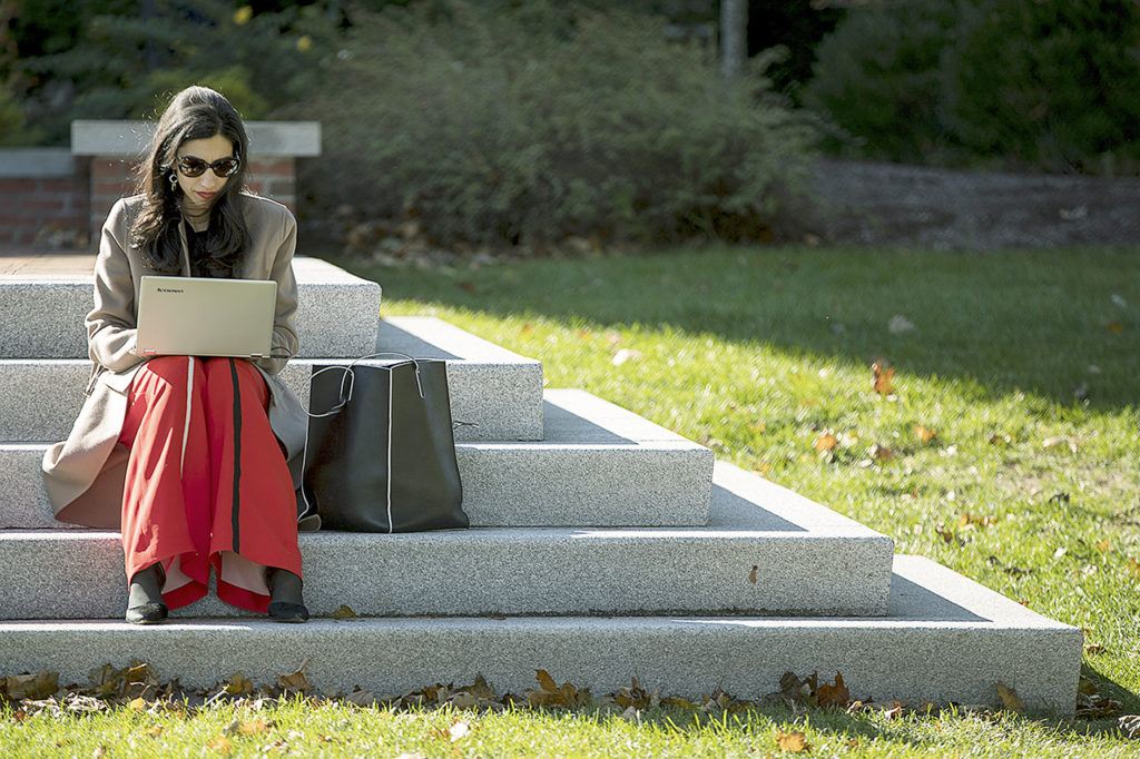 Senior aid Huma Abedin works on steps behind a rally for Democratic presidential candidate Hillary Clinton, accompanied by Sen. Elizabeth Warren, D-Mass., at St. Anselm College in Manchester, New Hampshire, on Monday, Oct. 24. (AP Photo/Andrew Harnik)

