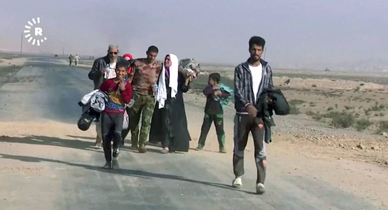 This image made from video by Rudaw News Agency shows a family fleeing Mosul, Iraq on Tuesday, Oct. 18. Residents who have endured more than two years of militant rule describe a city under siege, and say a new sense of terror has set in since Iraq announced the start of a long awaited operation to liberate its second largest city. (Rudaw News Agency via AP)
