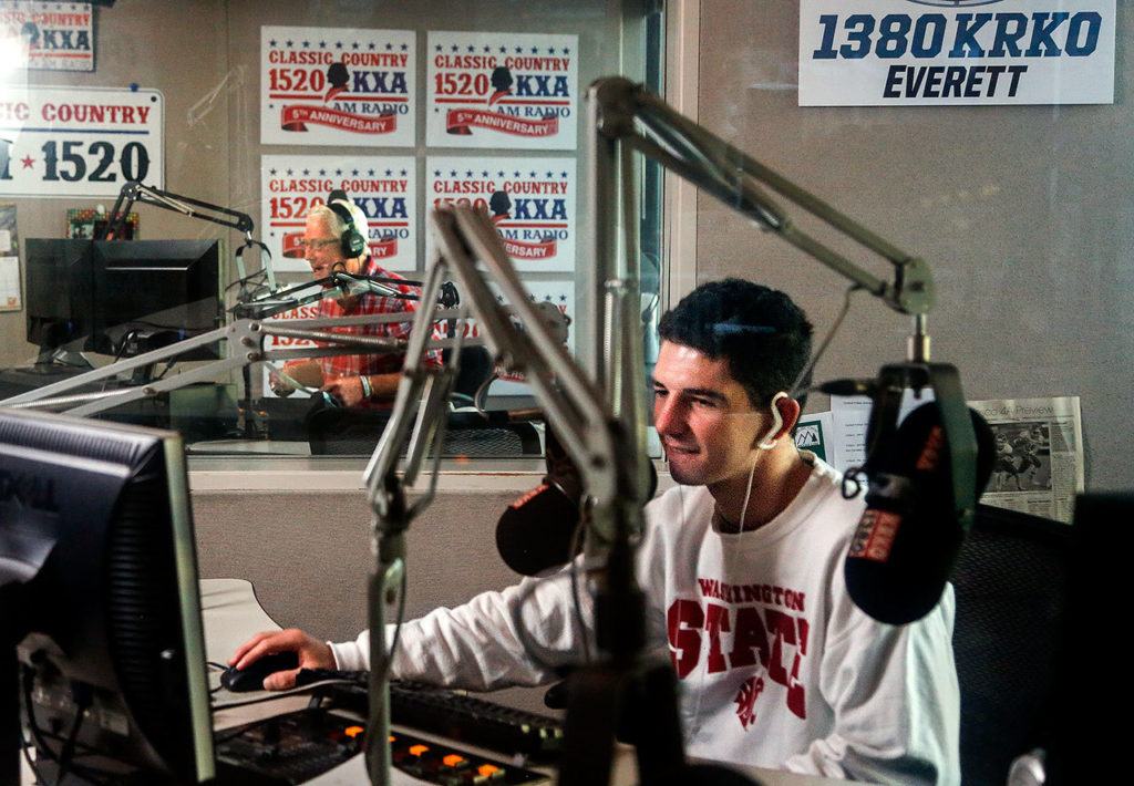 Viewed through sound proof window panes from a third work station, Sean Ryan (foreground) hosts 1380 KRKO while Stitch Mitchell (backround) hosts 1520 KKXA Wednesday morning. (Dan Bates / The Herald)
