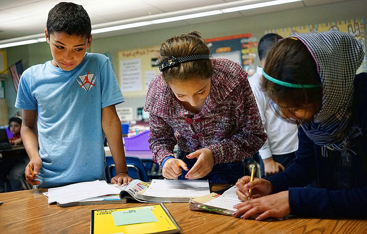 In this Oct. 4 photo, Abdulhamid Ashehneh, 12, works on English language exercises with fellow students in a class filled with refugee children at Cajon Valley Middle School in El Cajon, California. (AP Photo/Christine Armario)