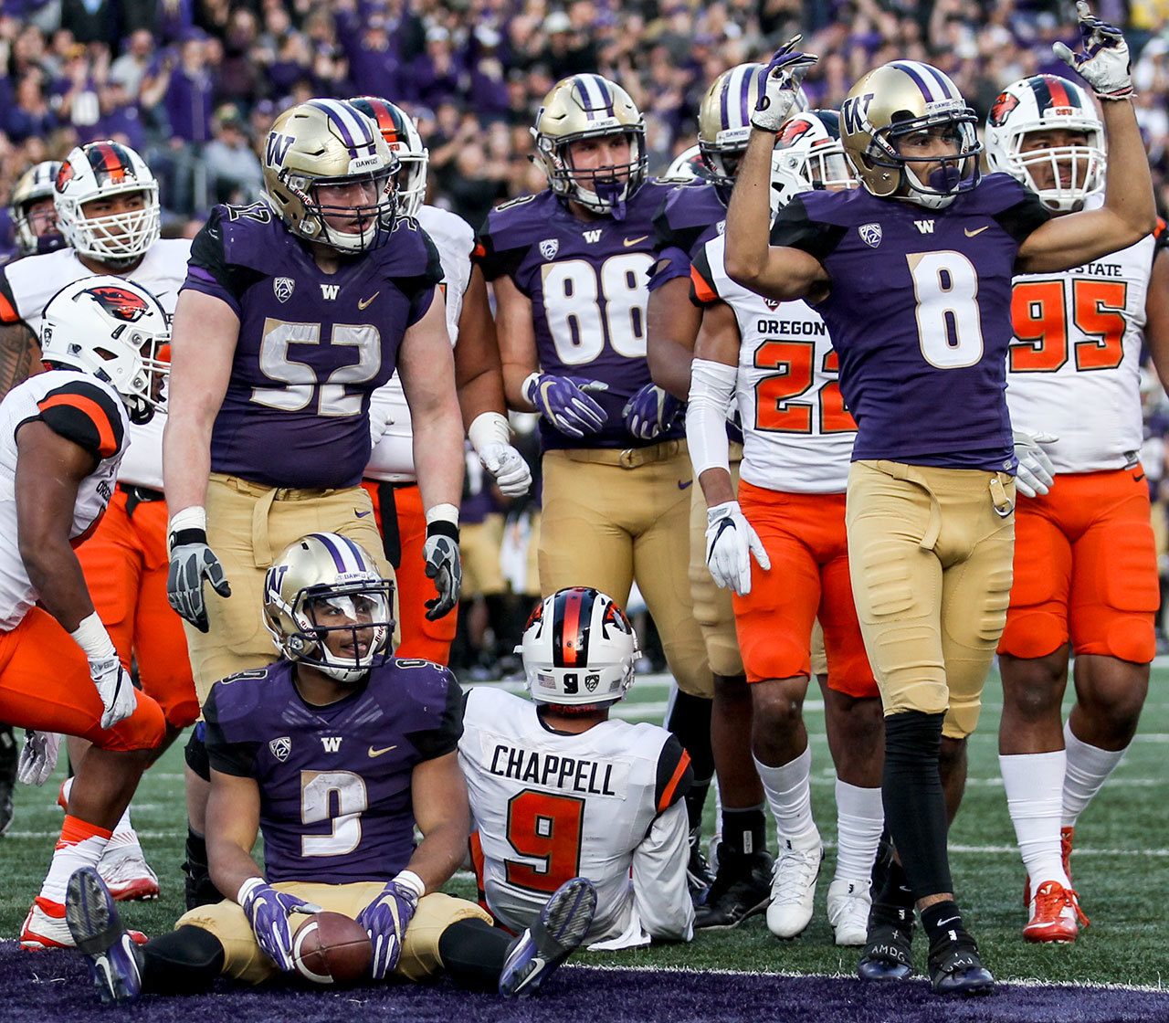 Washington’s Myles Gaskin (seated) along with members of the offense await the call from the line judge for the touchdown Saturday afternoon at Husky Stadium in Seattle. (Kevin Clark / The Herald)