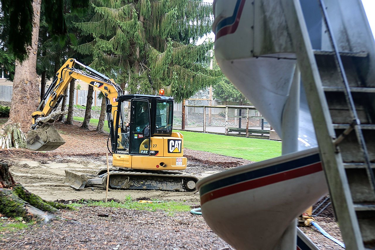 Crews work at Church Creek Park on Friday afternoon in Stanwood. (Kevin Clark / The Herald)