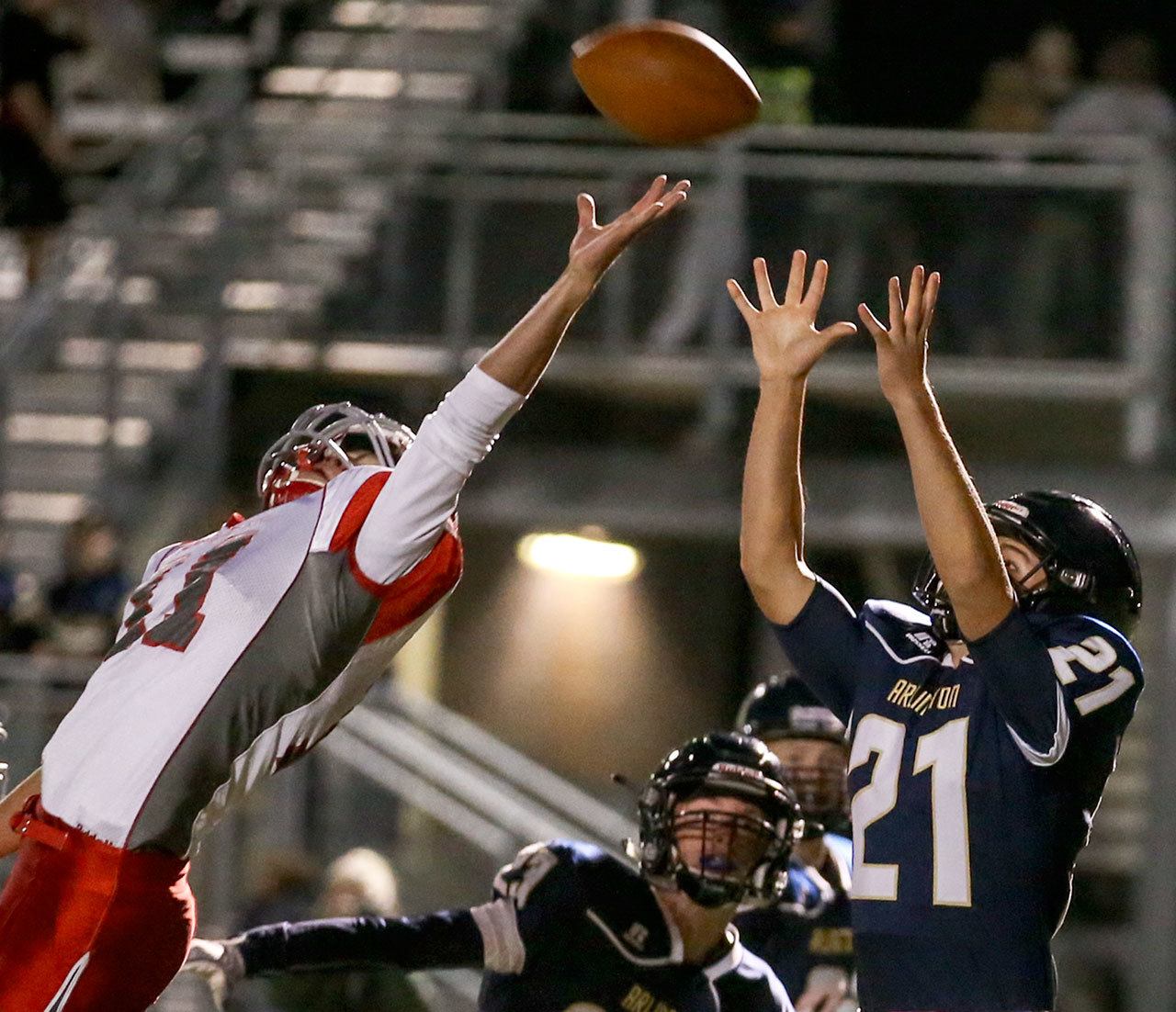 Arlington’s Cameron McCormack catches a two-point conversion over the outstretched hand of Stanwood’s Payton Greene during the annual Stilly Cup football game Friday night in Arlington. (Kevin Clark / The Herald)