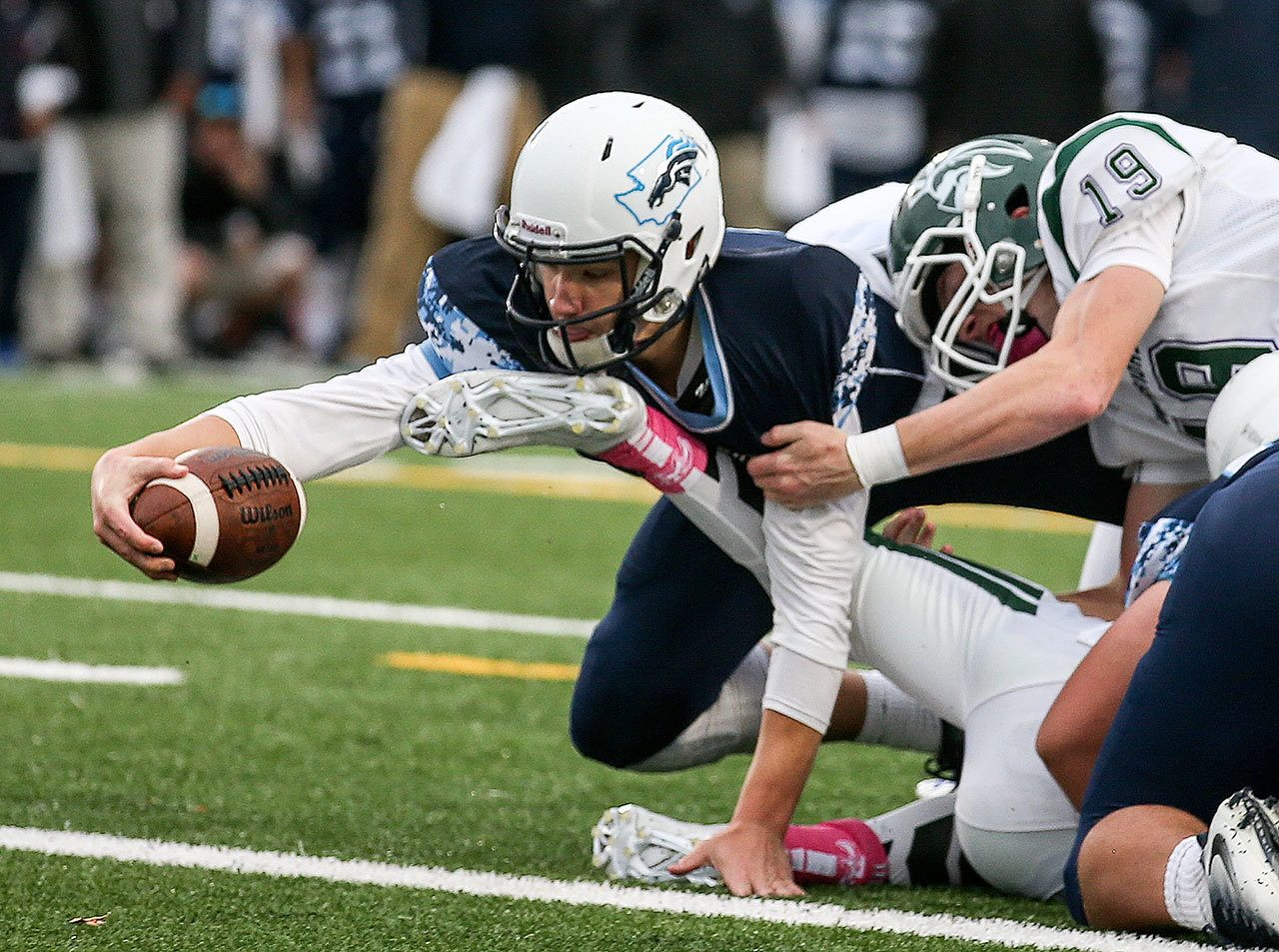 Meadowdale’s Drew Tingstad stretches for a touchdown with Edmonds-Woodway’s Anthony Lindamood holding on during a game Friday at Edmonds Stadium. (Kevin Clark / The Herald)