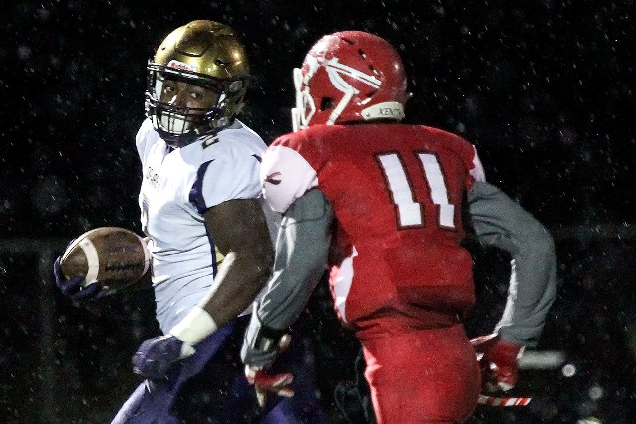 Oak Harbor’s Princeton Lollar looks back at Marysville Pilchuck’s Jordan Harris while running for a touchdown Thursday at Quil Ceda Stadium in Marysville. (Kevin Clark / The Herald)