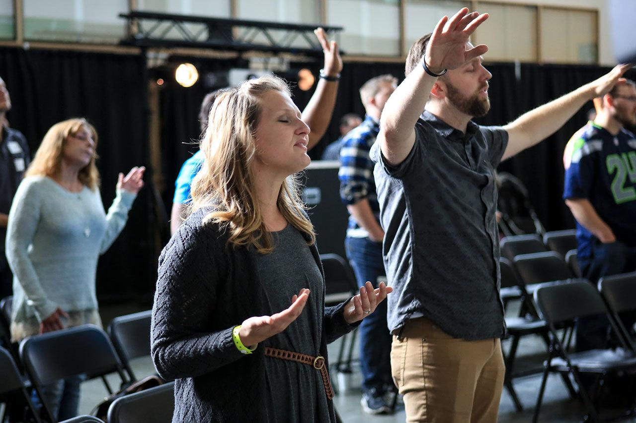 Rachel Butcher , center, with her husband Pastor Danny Butcher sing during service Sunday morning at Bethany Christian Assembly Marysville at Marysville Getchell High School in Marysvile on September 25, 2016. (Kevin Clark / The Herald)
