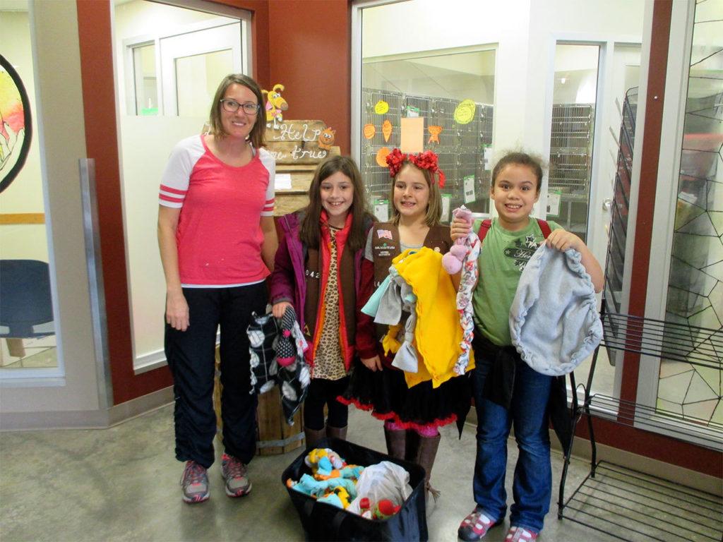 Members of Girl Scout Troop 44042 deliver a basket of toys and blankets they made for the animals at the Everett Animal Shelter, using money they made through cookie sales. (Contributed photo)
