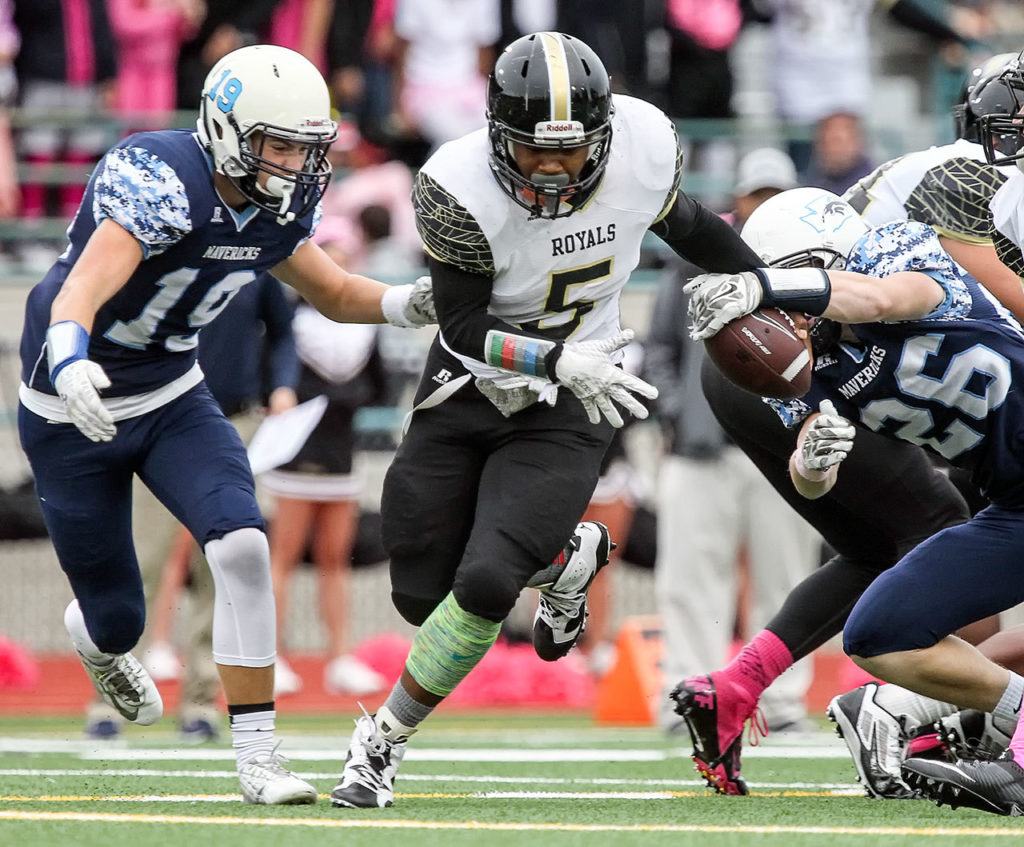 Meadowdale’s Brock Duncan (right) strips Lynnwood’s Alton Hammond forcing a fumble with Meadowdale’s Will Moloney closing Friday night at Edmonds Stadium. Meadowdale won 55-28. (Kevin Clark / The Herald)
