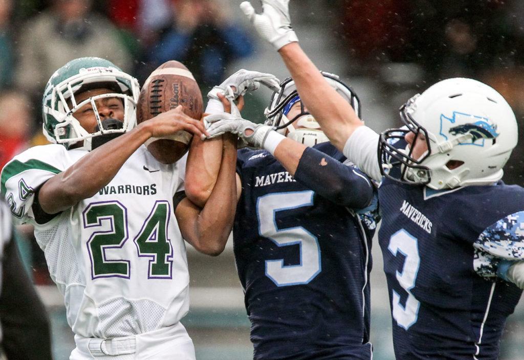 Meadowdale’s Haelin Roberts (center) and breaks up a pass intended for Edmonds-Woodway’s Jalen Nash with Meadowdale’s Will Schafer (right) trailing during a game Friday at Edmonds Stadium. (Kevin Clark / The Herald)
