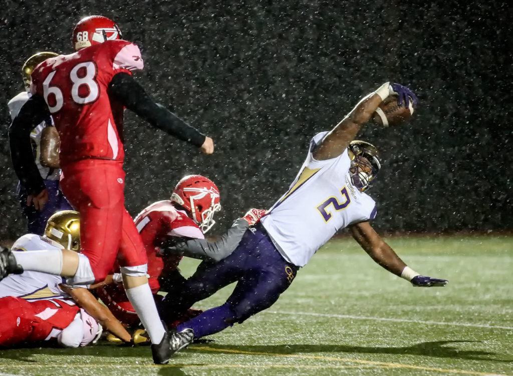 Oak Harbor’s Princeton Lollar reaches for extra yardage with Marysville Pilchuck defenders hanging on during a game Thursday at Quil Ceda Stadium in Marysville. (Kevin Clark / The Herald)
