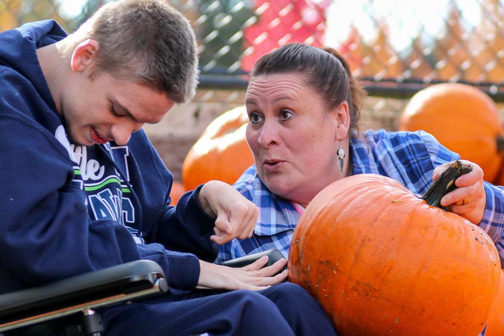 Deanna Locke (right) shows off her pumpkin selection to her son, Ian Locke, on Saturday morning at Fred Meyer in Monroe. (Kevin Clark / The Herald)
