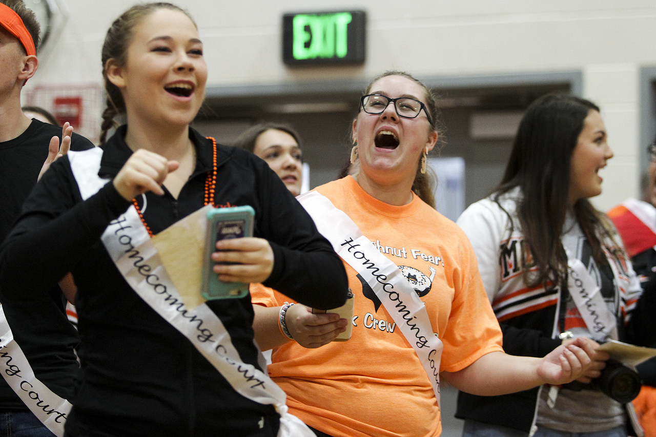 Monroe High School homecoming nominees Jada Castor (left), from the dance team, and Ashley Donaldson, from the link crew club that helps incoming freshmen, dance and cheer during an assembly at the school on Friday morning. (Ian Terry / The Herald)
