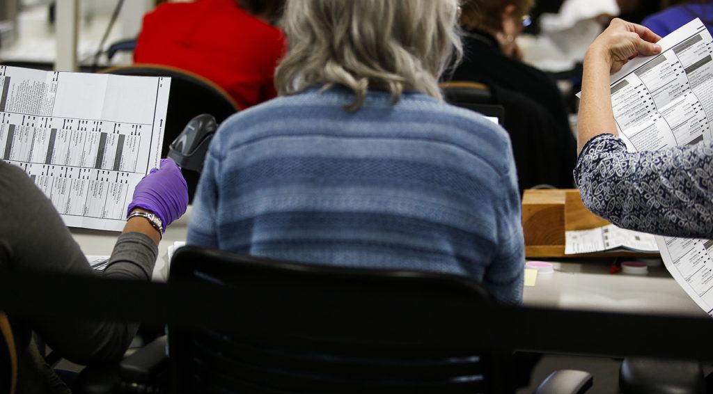 Workers examine ballots at the Snohomish County ballot return center in Mukilteo on Thursday, Oct. 27. (Ian Terry / The Herald)
