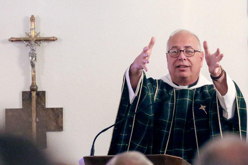 Father Tim Sauer gives the history of the church during the 100 year celebration Mass at St. John Vianney Catholic Church in Darrington in September. (Kevin Clark / The Herald)
