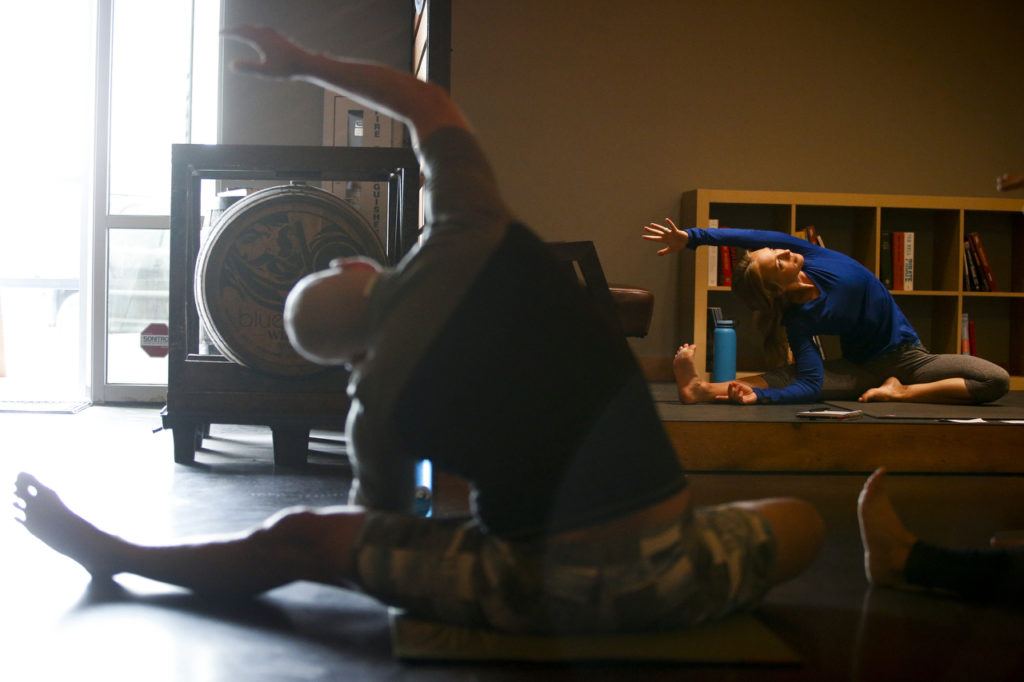 Carly Hayden (right) teaches a YogaMosa class at Bluewater Organic Distilling in Everett. (Ian Terry / The Herald)
