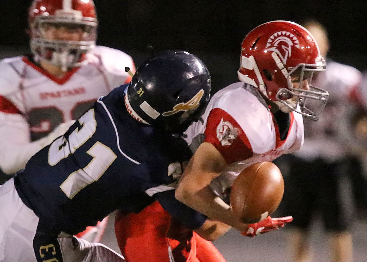 Arlington’s Payton Bastien breaks up a pass intended for Stanwood’s Trygve DeBoer during the annual Stilly Cup football game Friday night in Arlington. (Kevin Clark / The Herald)
