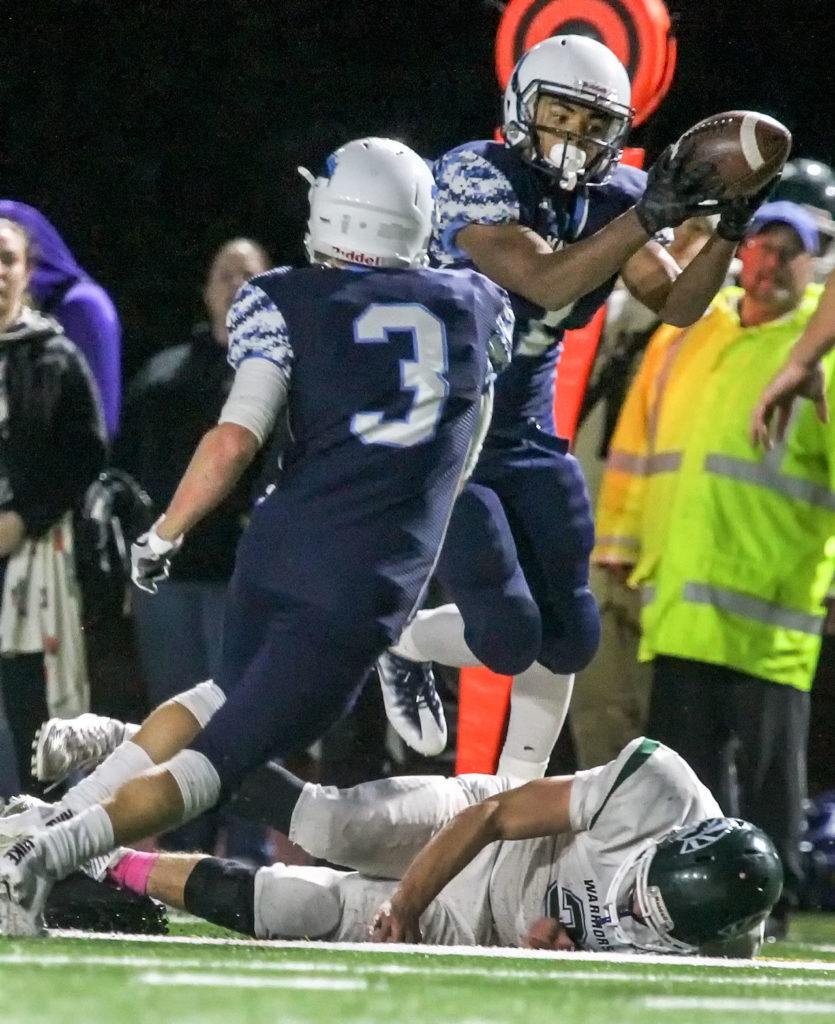 Meadowdale’s Jashon Butler intercepts a pass intended for Edmonds-Woodway’s Henry Tillman (bottom) with Meadowdale’s Will Schafer looking on during a game Friday at Edmonds Stadium. (Kevin Clark / The Herald)
