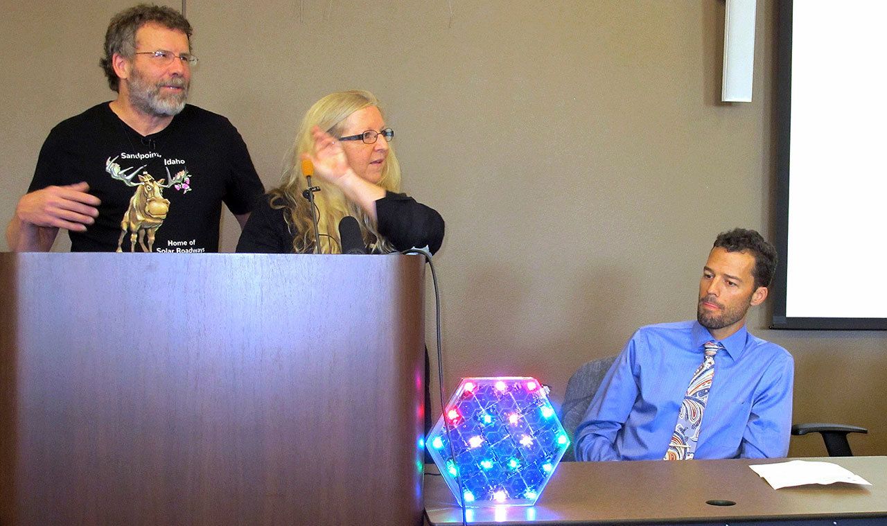 Solar Roadways founders Scott Brusaw (left) and Julie Brusaw display a one-third sized replica of one of their solar pavement panels at a news conference Setp. 30 in Sandpoint, Idaho, as Sandpoint Mayor Shelby Rognstad watches. (AP Photo/Nicholas K. Geranios)